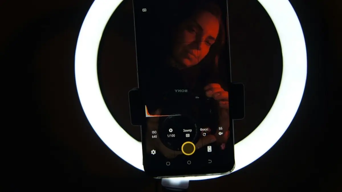 A cell phone sitting in front of a circular light